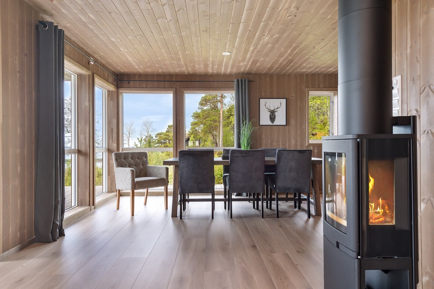 Lyst stuerom i tre med peis og store vinduer